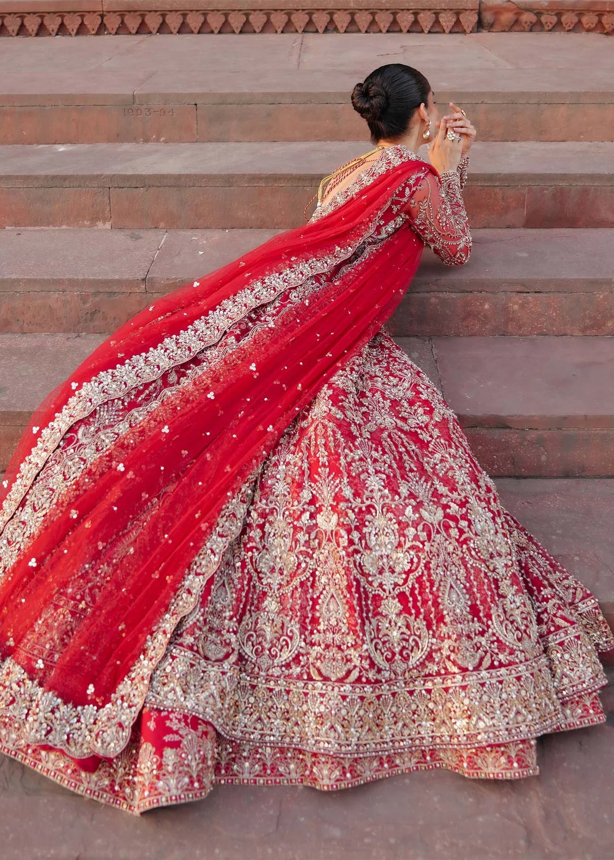 ARMAL – Red bridal pishwas with hand embroidery, Korean silk lehenga, and net dupatta. Stitched Pakistani bridal outfit online at Pakistanimoda.