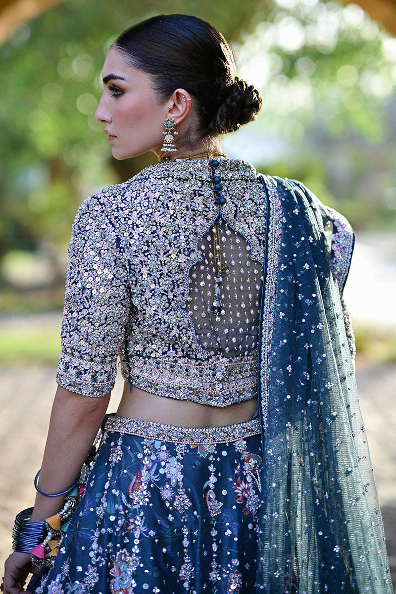 Teal printed Pakistani bridal lehenga choli with sweetheart neckline, geometric embellishments, and appliquéd net dupatta – perfect for brides in UK and Canada.