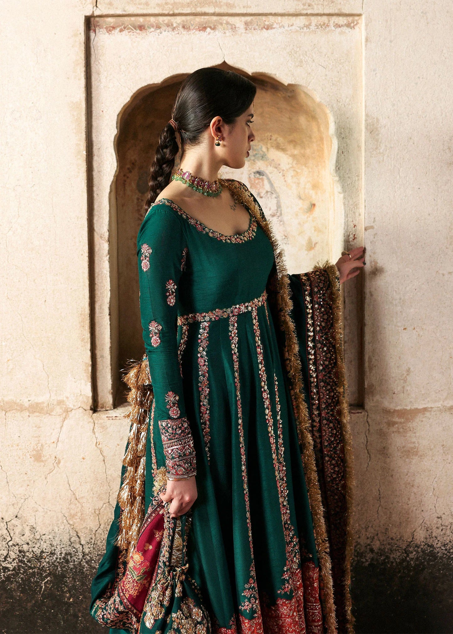 Emerald green raw silk embroidered pishwas with multicolored borders, paired with churidar and embroidered shawl – Hussain Rehar Festive ’25 at Pakistanimoda.
