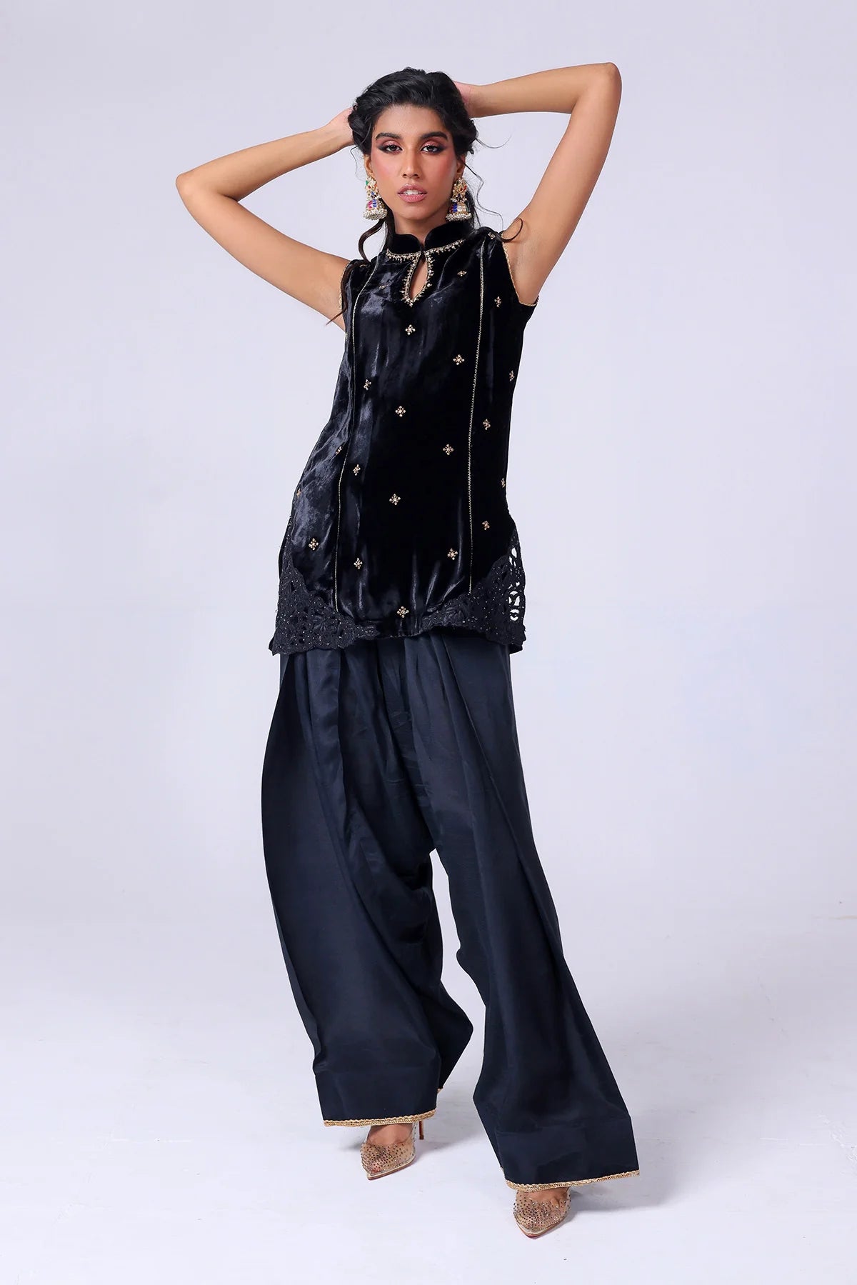 Black velvet sleeveless shirt with gold embroidery, wide raw silk shalwar, and organza dupatta – Pakistani festive outfit at Pakistanimoda