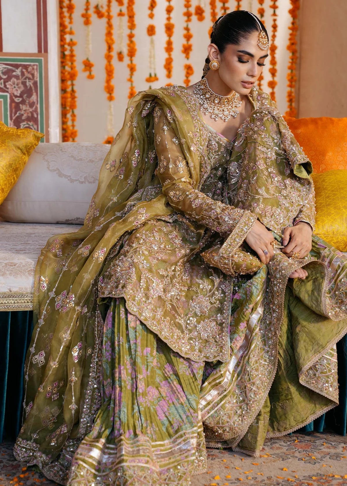 AMAL – Olive green angrakha style sharara suit with embroidered organza top, printed crushed sharara, and dupatta. Online at Pakistanimoda.