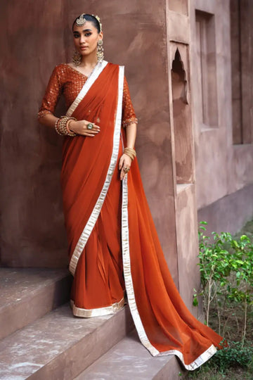 Coreene rust orange embroidered chiffon saree with blouse for wedding and festive wear
