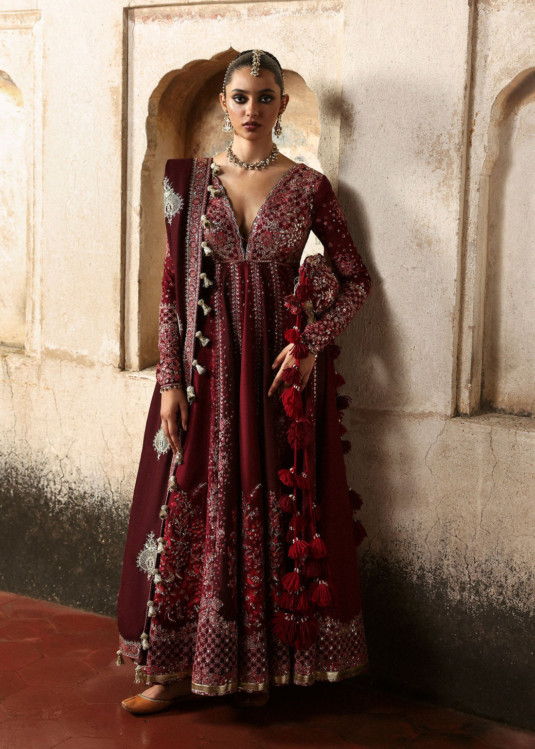 Model wearing Gulnar burgundy & maroon embroidered raw silk pishwas with churidar and shawl from Hussain Rehar Massarat Festive ’25 Collection.