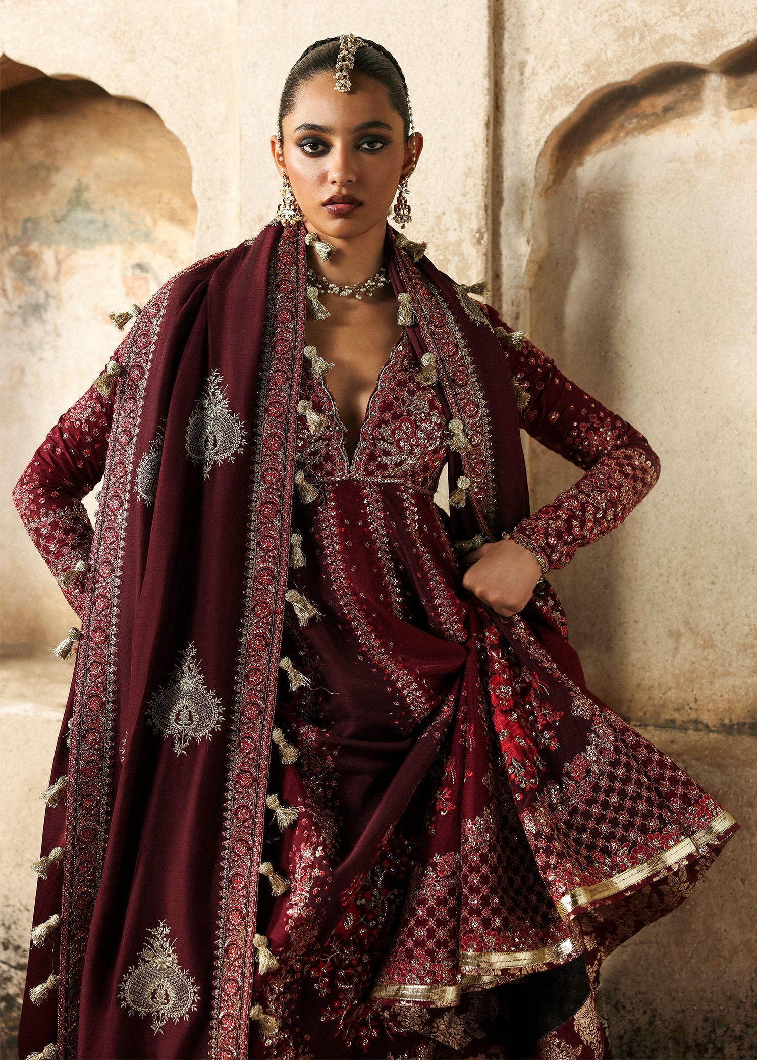 Model wearing Gulnar burgundy & maroon embroidered raw silk pishwas with churidar and shawl from Hussain Rehar Massarat Festive ’25 Collection.