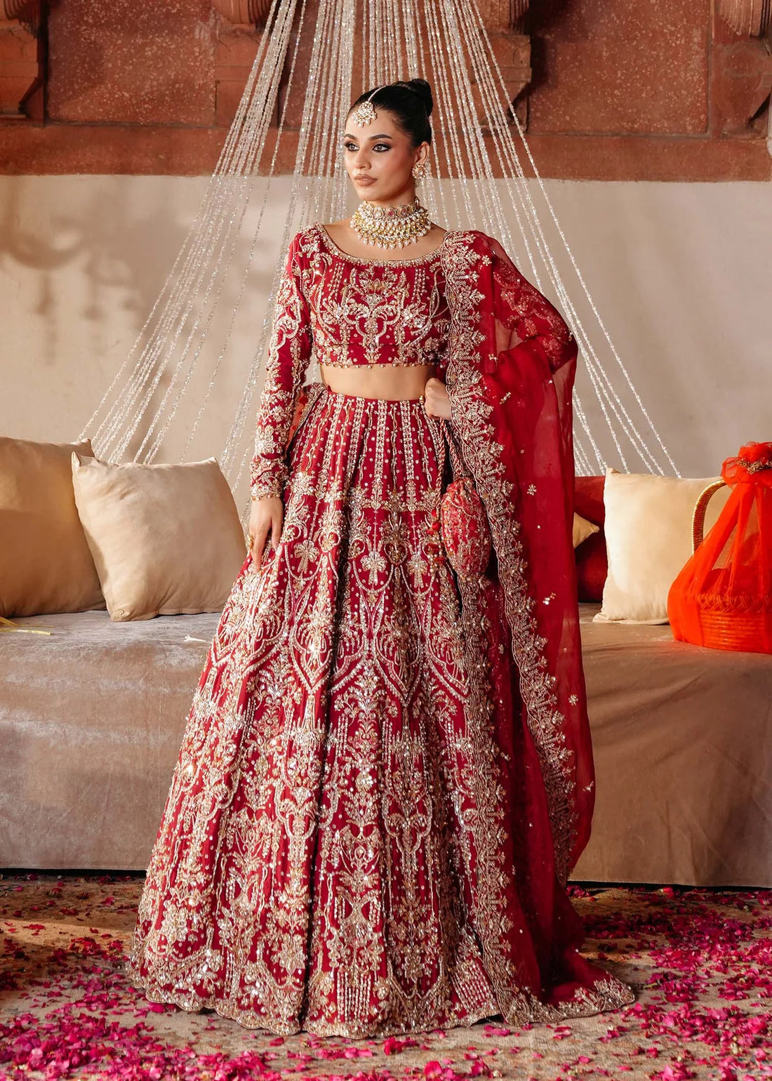 KRISHAM – Red bridal lehenga choli in Korean silk with organza dupatta and heavy embroidery. Stitched bridal outfit online at Pakistanimoda.
