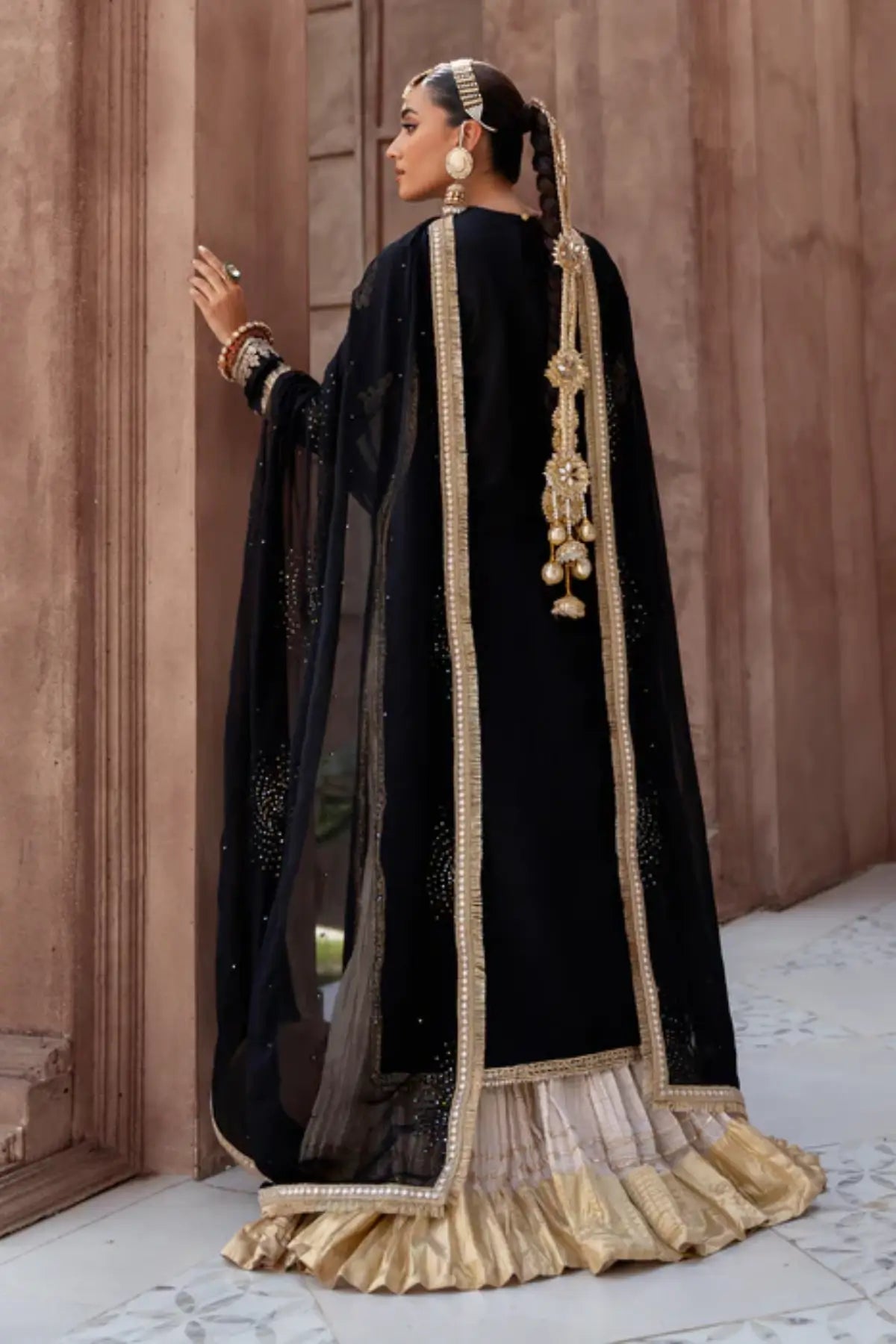 Black embroidered raw silk sharara suit by Lunia with chiffon dupatta for festive and wedding wear