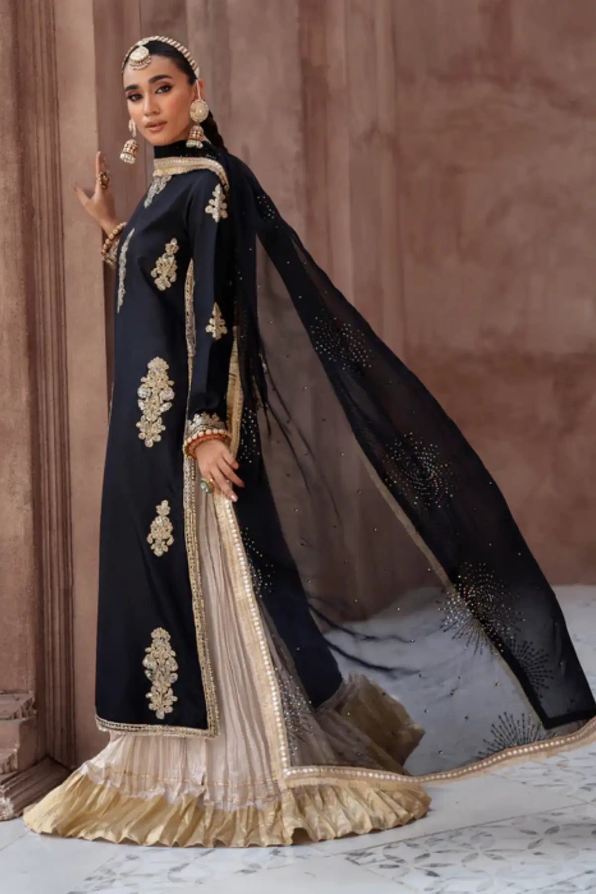 Black embroidered raw silk sharara suit by Lunia with chiffon dupatta for festive and wedding wear