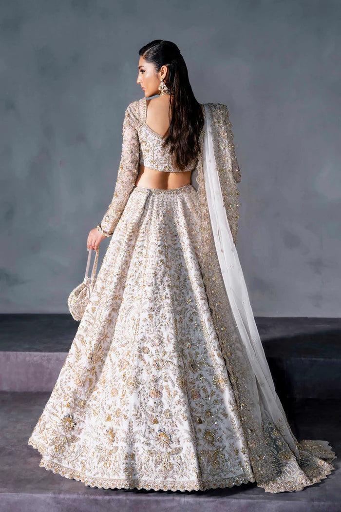 White and gold Pakistani bridal lehenga with floral embroidery, full sleeves, and sheer dupatta – perfect for South Asian weddings abroad.