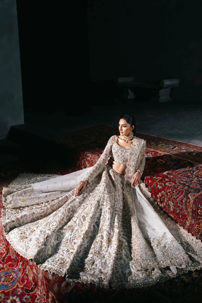 White and gold Pakistani bridal lehenga with floral embroidery, full sleeves, and sheer dupatta – perfect for South Asian weddings abroad.