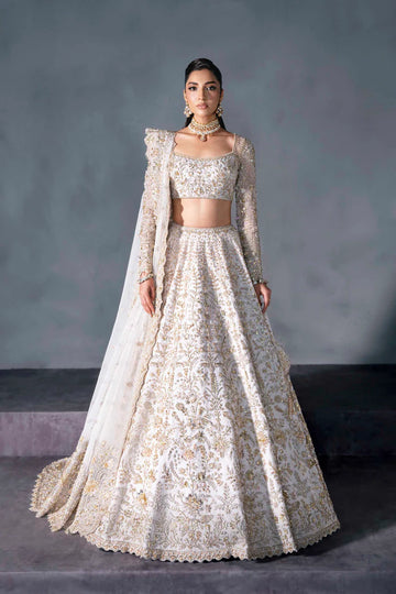 White and gold Pakistani bridal lehenga with floral embroidery, full sleeves, and sheer dupatta – perfect for South Asian weddings abroad.