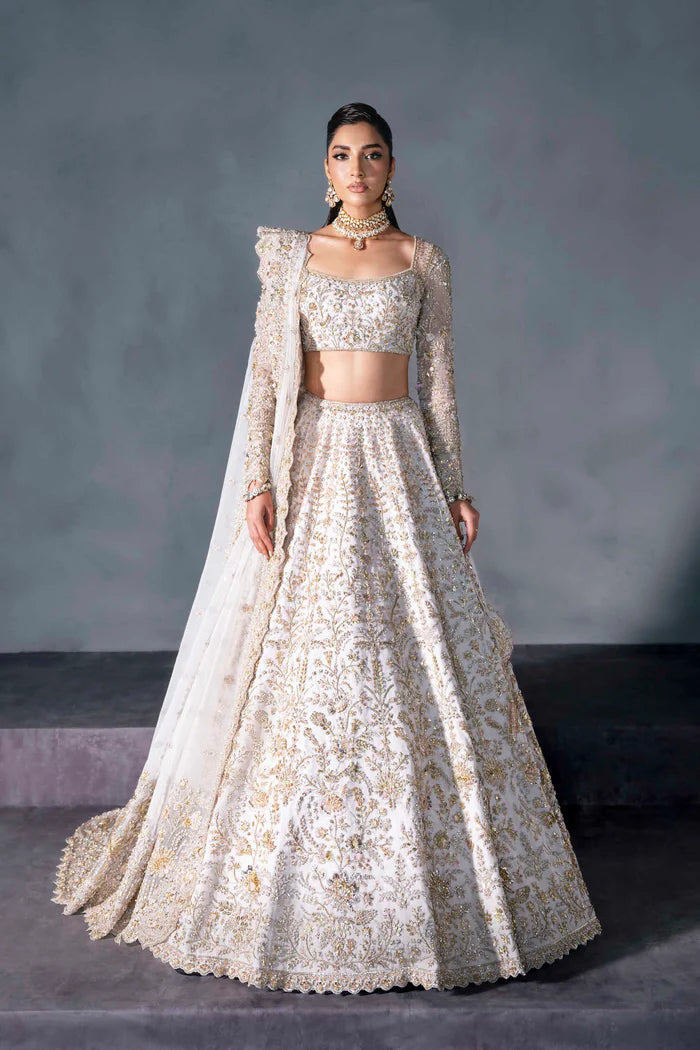 White and gold Pakistani bridal lehenga with floral embroidery, full sleeves, and sheer dupatta – perfect for South Asian weddings abroad.