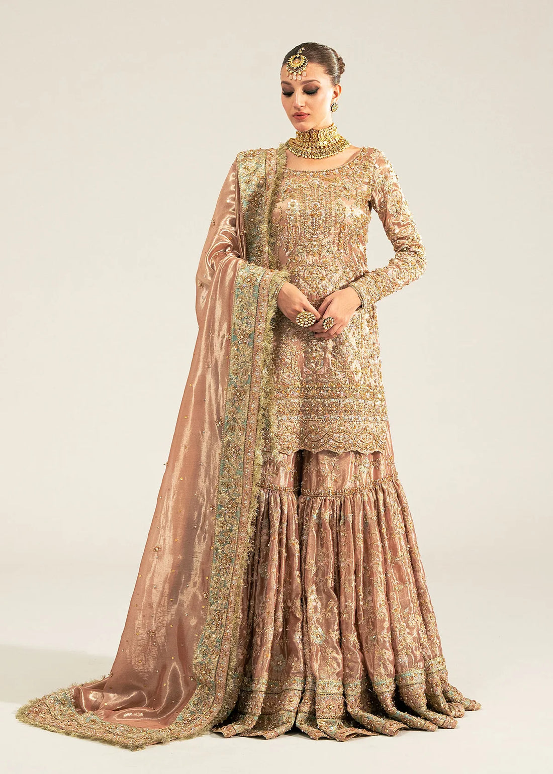 Meeram pink bridal gharara outfit with tissue dupatta and hand embellishments by Kanwal Malik, featuring pearl and sequin work.