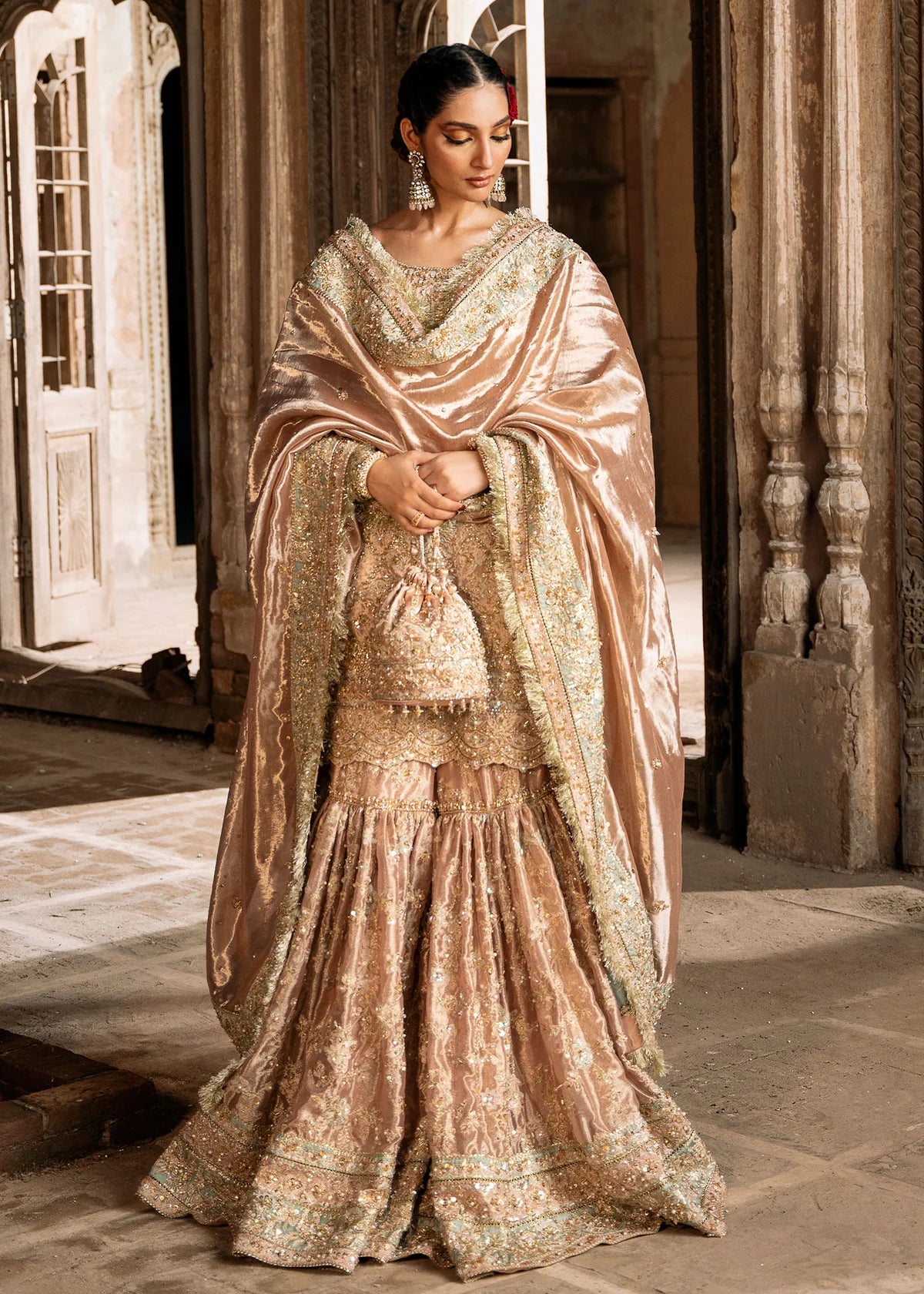 Meeram pink bridal gharara outfit with tissue dupatta and hand embellishments by Kanwal Malik, featuring pearl and sequin work.