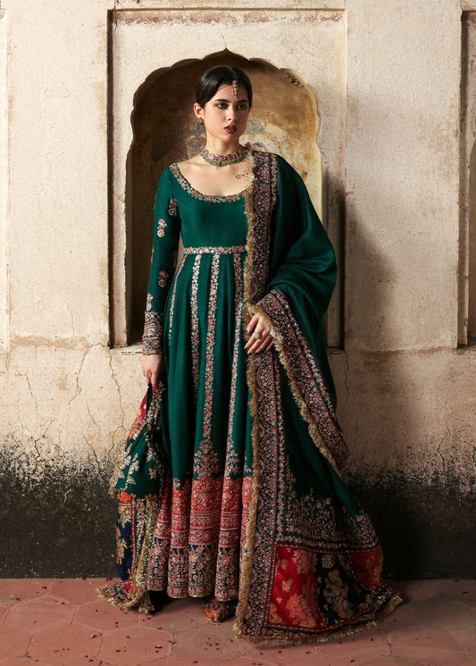 Emerald green raw silk embroidered pishwas with multicolored borders, paired with churidar and embroidered shawl – Hussain Rehar Festive ’25 at Pakistanimoda.