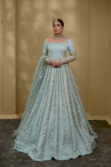 Sky blue silk chiffon gown with embellished neckline, floral sleeves, gota and mirror work, paired with zari organza dupatta – ideal for Pakistani weddings and formal events.