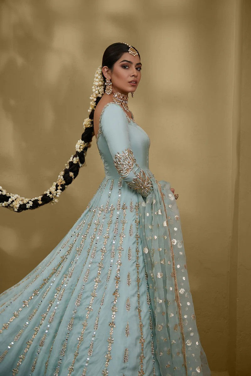 Sky blue silk chiffon gown with embellished neckline, floral sleeves, gota and mirror work, paired with zari organza dupatta – ideal for Pakistani weddings and formal events.