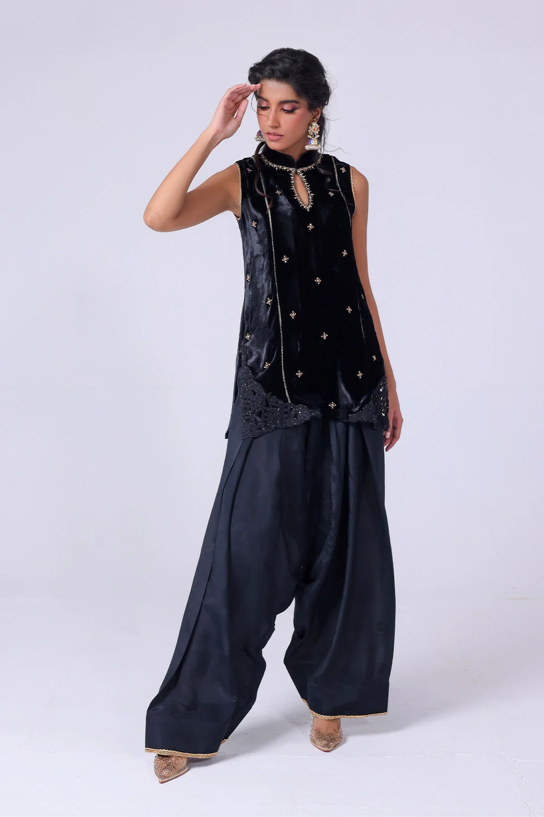 Black velvet sleeveless shirt with gold embroidery, wide raw silk shalwar, and organza dupatta – Pakistani festive outfit at Pakistanimoda