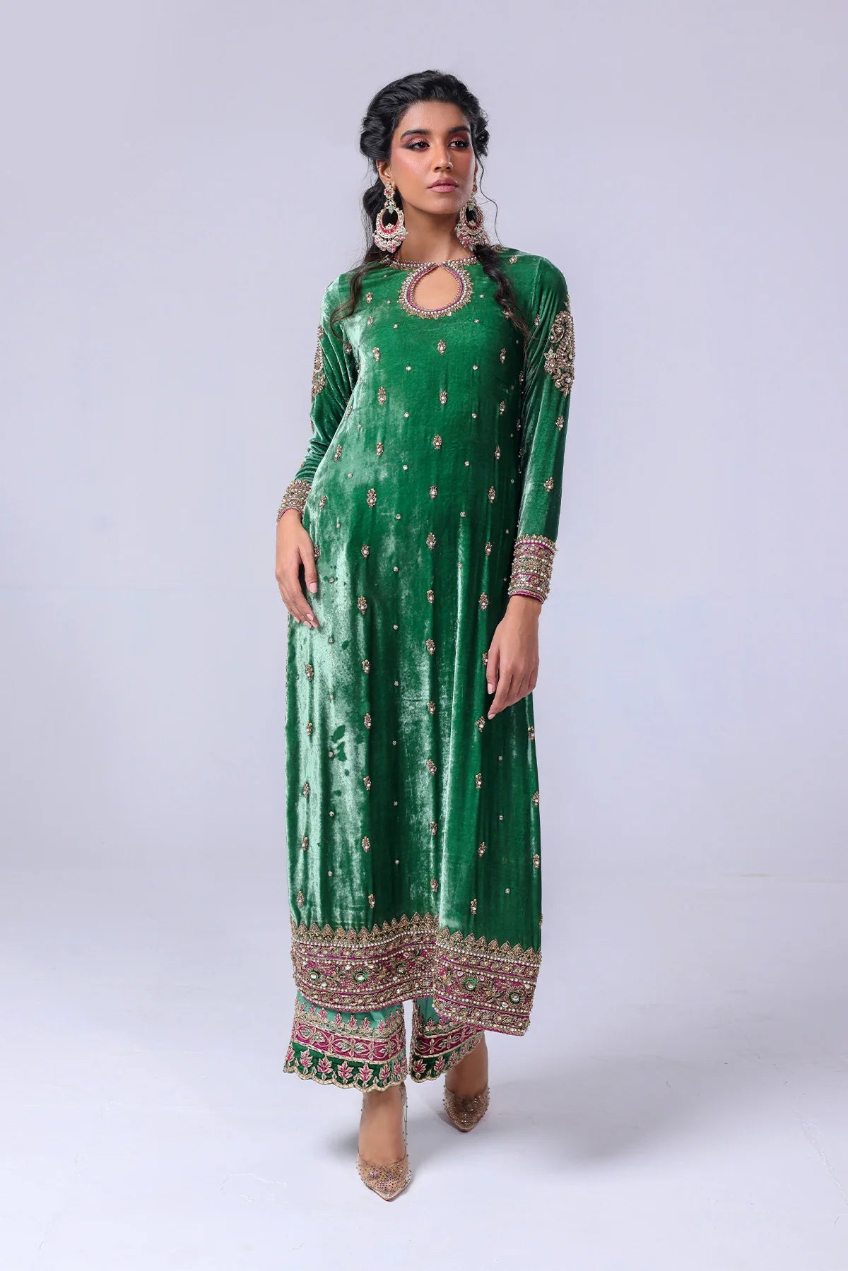 Green velvet shirt with keyhole neckline, naqshi and dabka handwork, silk pants with embellished hem, and matching organza dupatta – festive wear 2025.

