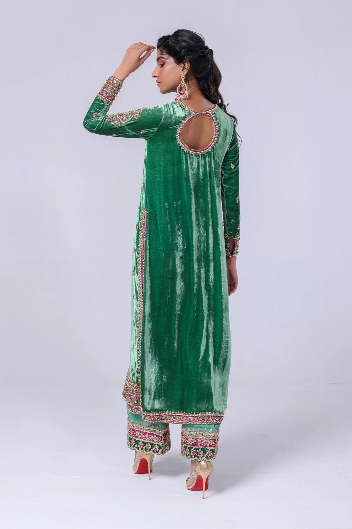 Green velvet shirt with keyhole neckline, naqshi and dabka handwork, silk pants with embellished hem, and matching organza dupatta – festive wear 2025.

