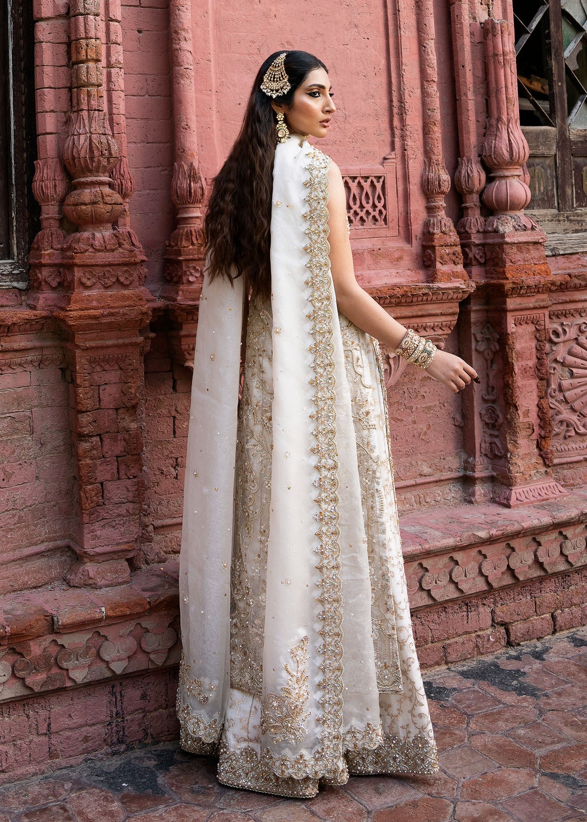 Nisha stitched ivory sharara outfit by Kanwal Malik with hand-embellished Kathan organza shirt, lawn silk sharara, and a sequin-sprayed organza dupatta.