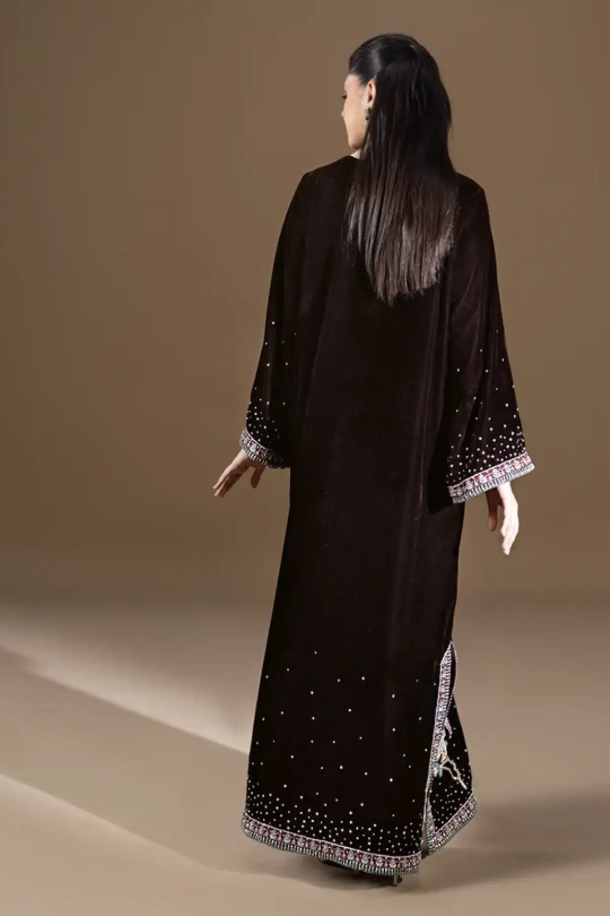 Nocturne dark chocolate brown shiny velvet stitched kaftan with pastel resham floral embroidery, silver detailing, sequin embellishments and V-neckline.