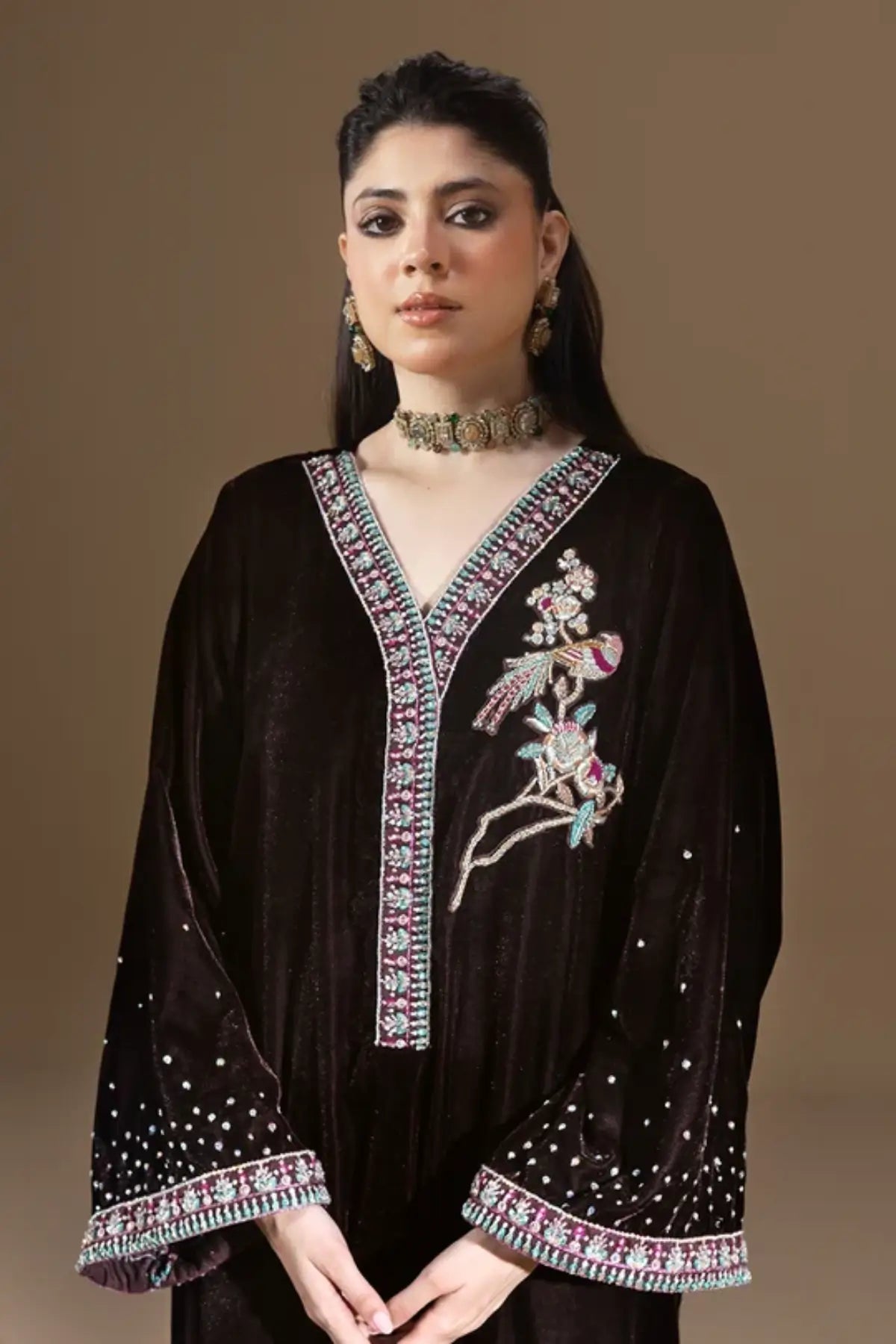 Nocturne dark chocolate brown shiny velvet stitched kaftan with pastel resham floral embroidery, silver detailing, sequin embellishments and V-neckline.