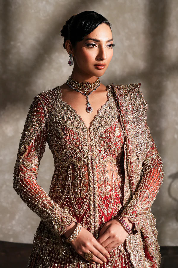 Pakistani bridal pishwas with raw silk lehenga for USA brides, featuring hand-embellished naqshi, dabka, mirror work, and mukesh with a sheer net dupatta in a graceful traditional design.