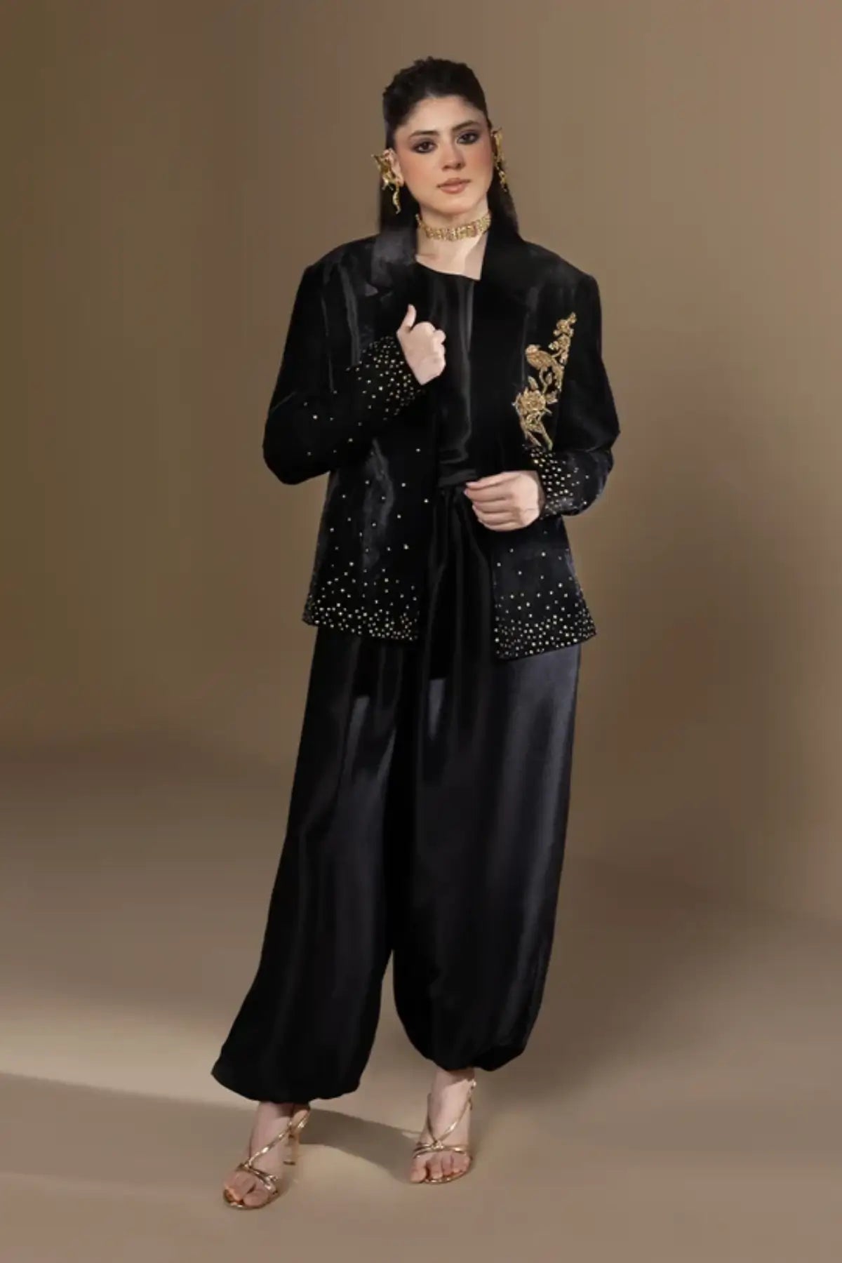 Odyssey black velvet blazer with gold zardozi floral embroidery, pure raw silk cowl and matching black balloon pants, luxury stitched formal outfit.