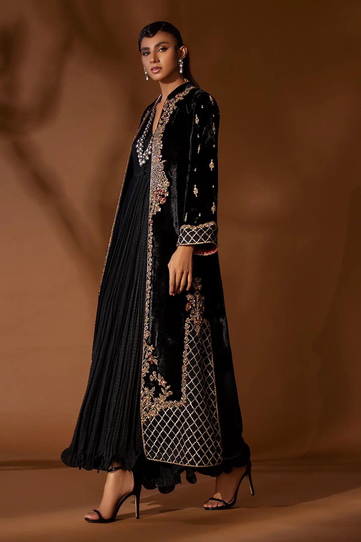 Black velvet jacket with antique gold kora, dabka & resham, paired with crushed silk inner shirt – modern Pakistani formal outfit for 2025 events.