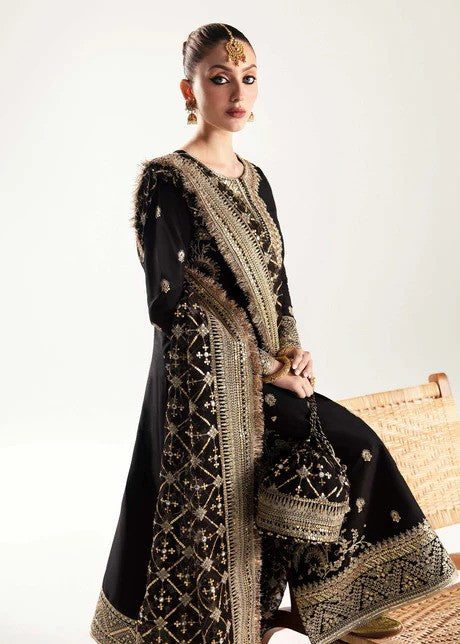 Black raw silk frock with churidar pajama and sequined organza dupatta.