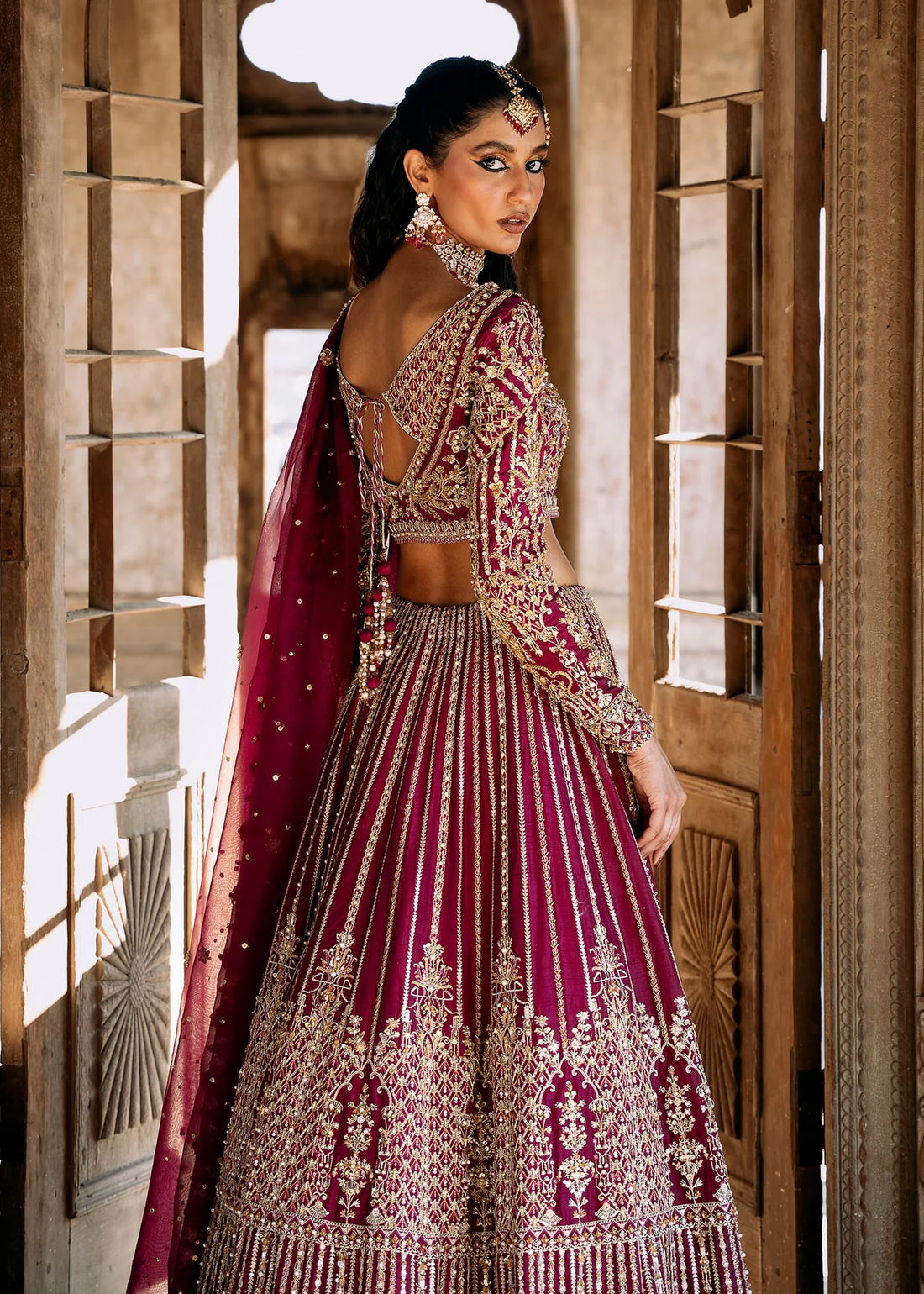 Raina stitched plum lehenga choli set by Kanwal Malik in Korean raw silk, featuring gold and silver hand embellishments with an organza dupatta.