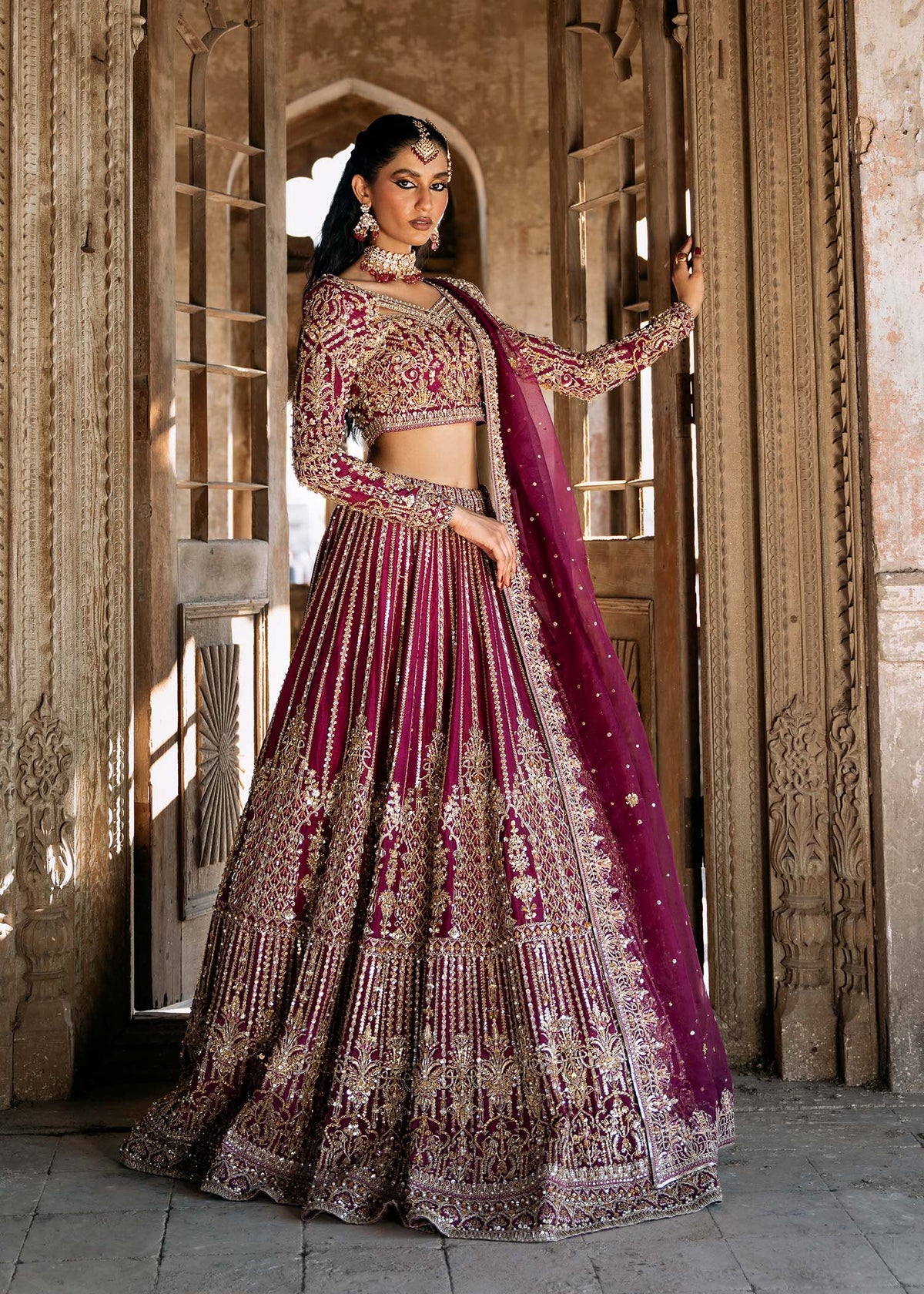 Raina stitched plum lehenga choli set by Kanwal Malik in Korean raw silk, featuring gold and silver hand embellishments with an organza dupatta.