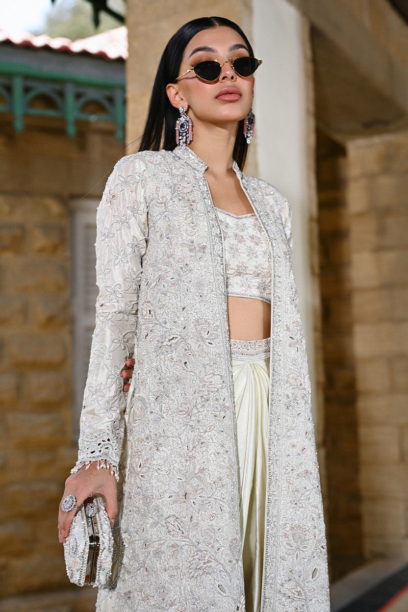 Designer ivory raw silk outfit with a structured cutwork jacket, shamooz silk draped skirt, and bandeau – modern Pakistani formal wear for weddings in USA, UK, and Canada.