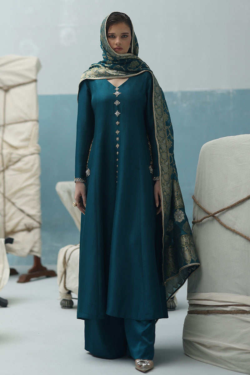 Peacock teal raw silk shirt with gold and silver zardozi, crepe silk culottes, and Banarasi chiffon dupatta – formal Pakistani ensemble for global events.