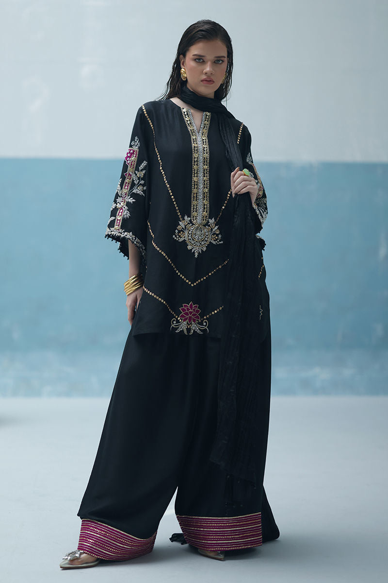 Formal black Pakistani raw silk outfit with embellished kurta, farshi culottes, and crushed dupatta – ideal for weddings and Eid abroad.