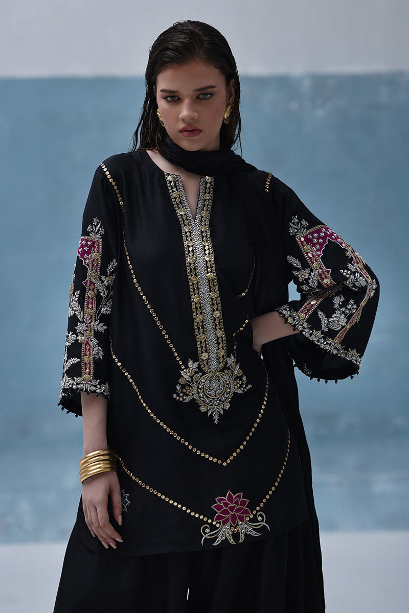 Formal black Pakistani raw silk outfit with embellished kurta, farshi culottes, and crushed dupatta – ideal for weddings and Eid abroad.