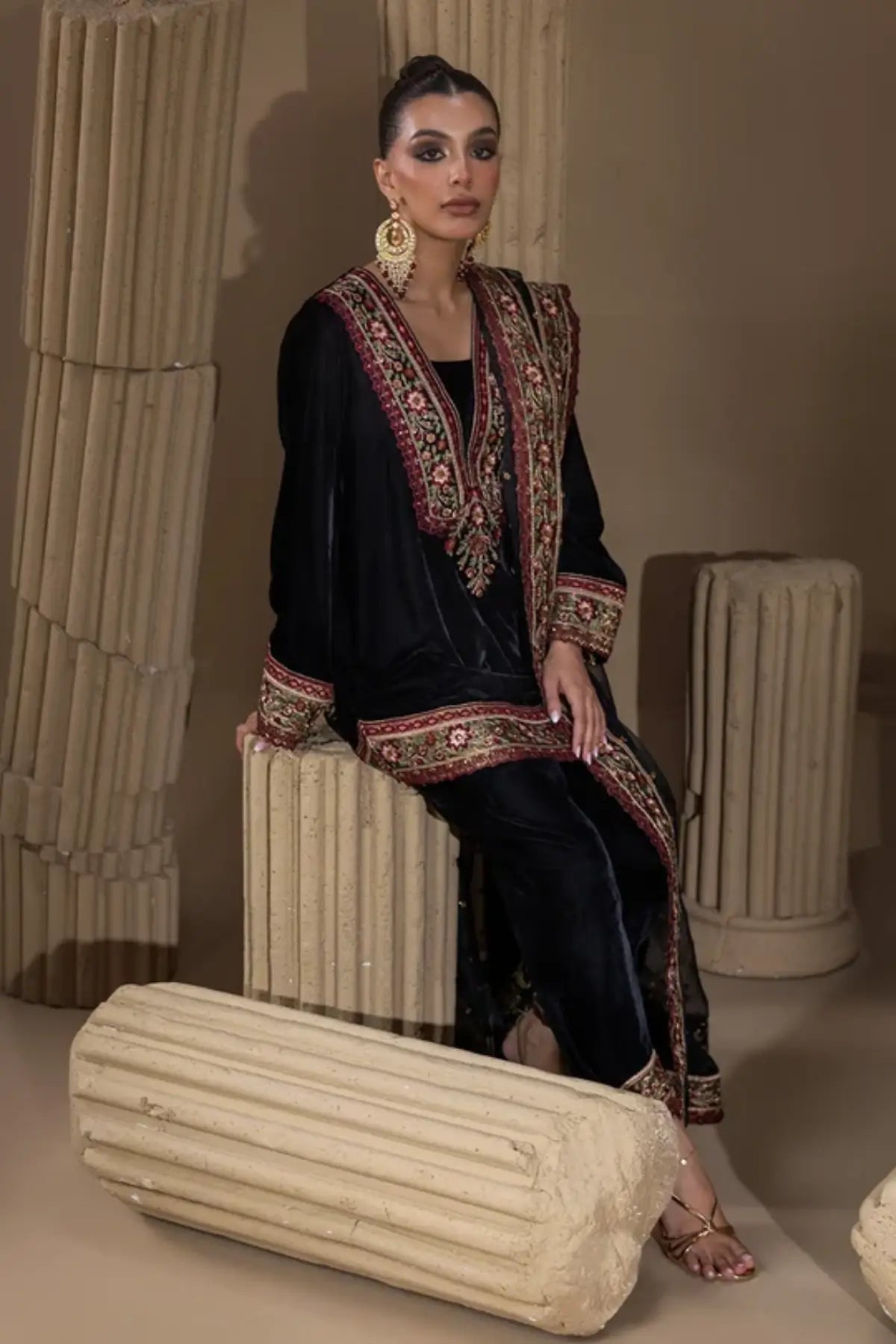 Shab-e-Gulposh jet black zardozi embroidered velvet stitched suit with maroon and gold detailing, matching velvet shalwar and organza dupatta.