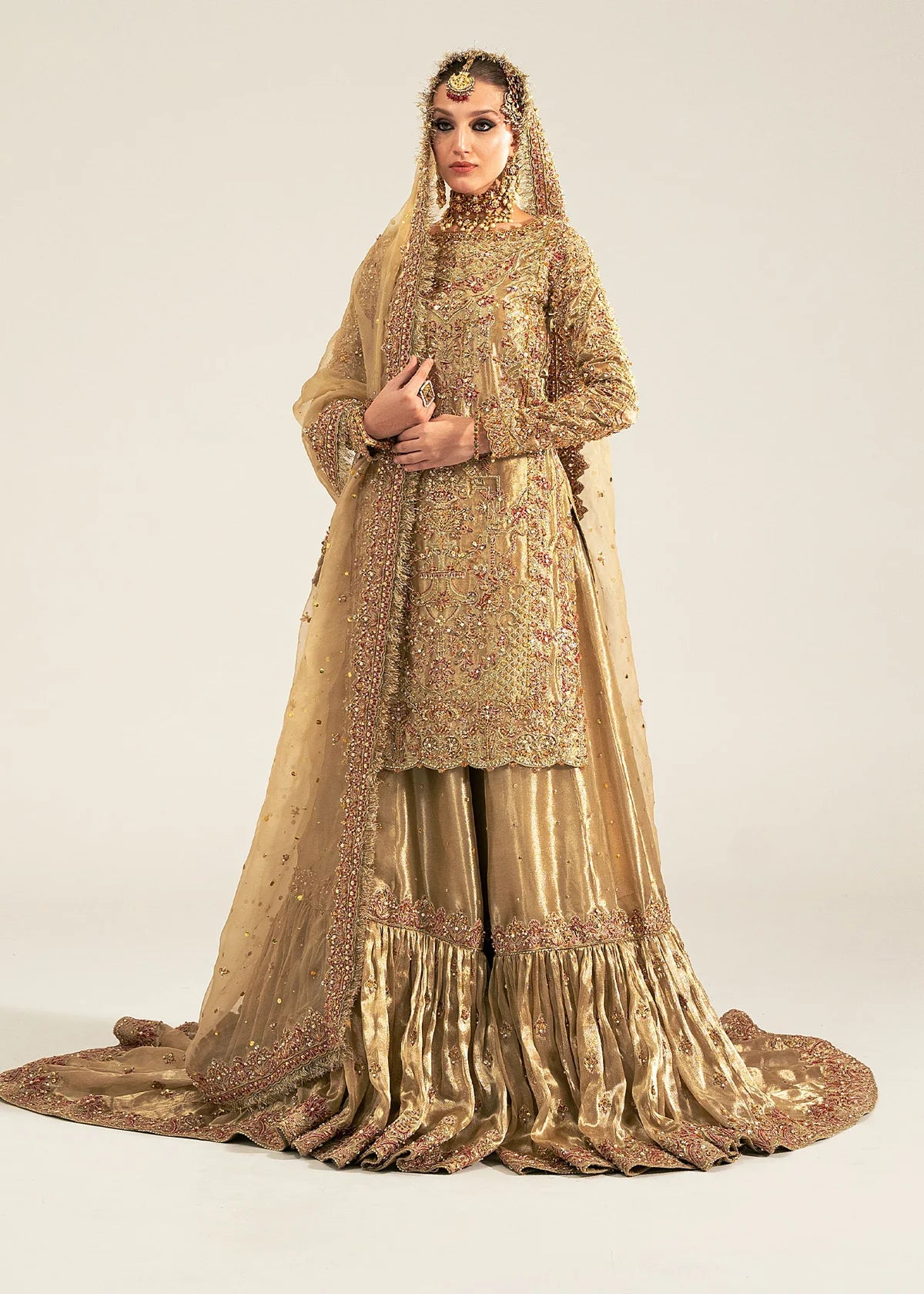 Gold stitched bridal gharara outfit by Kanwal Malik featuring pearl and sequin work with a mukesh dupatta—perfect for brides on their special day.