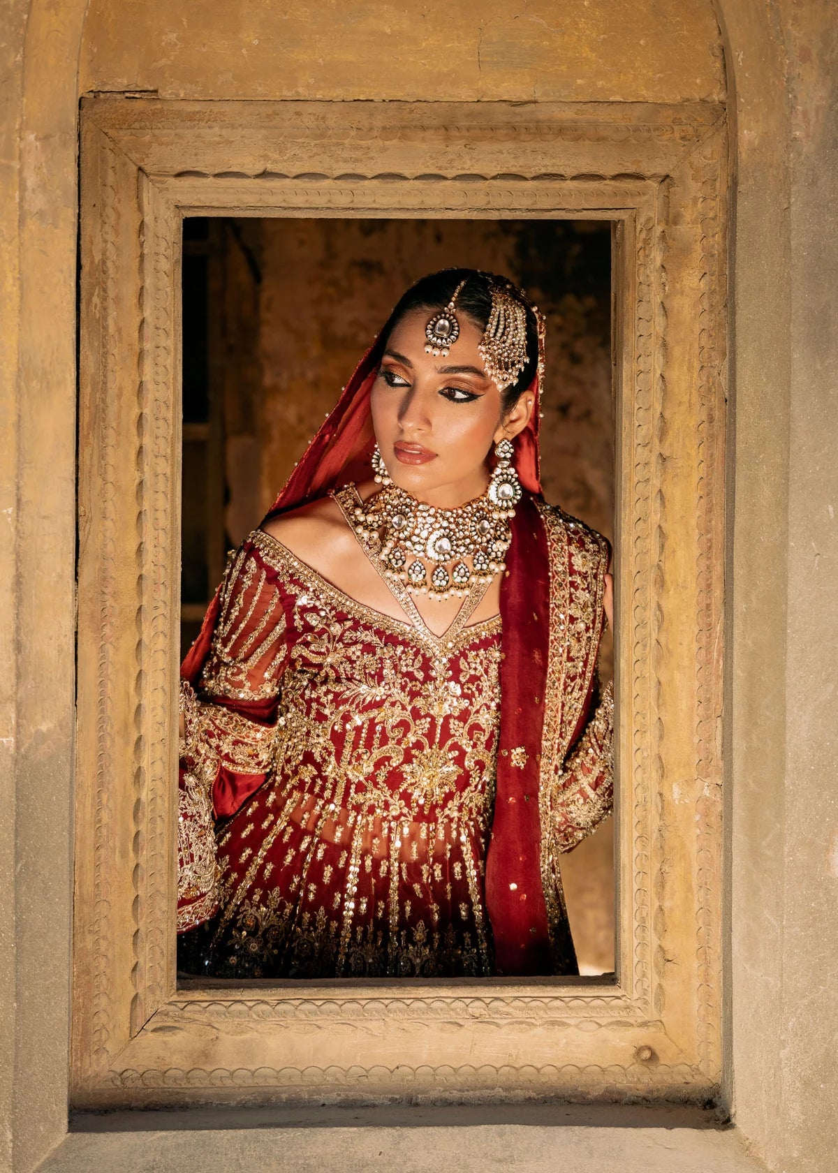 Shirin red stitched bridal pishwas and lehenga by Kanwal Malik with hand embellishments, paired with dual organza dupattas for wedding and festive events.