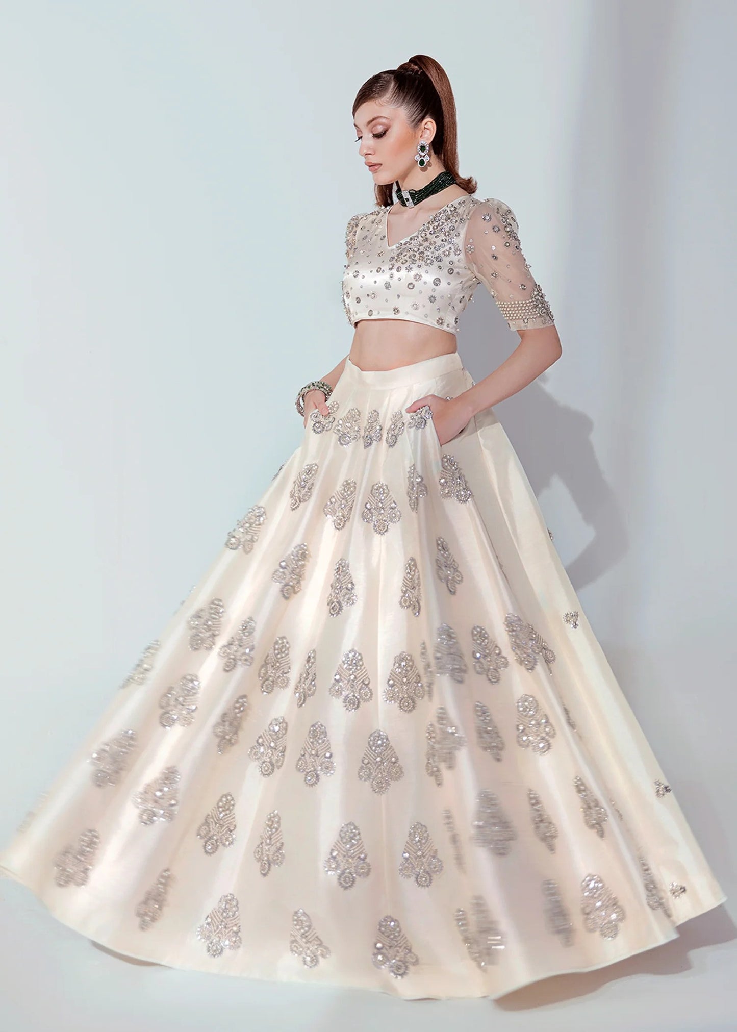 White and silver Pakistani lehenga choli with pearl, sequin, and bead embellishments, v-neck puffed sleeve choli, and an organza dupatta – ideal for weddings and formal events.