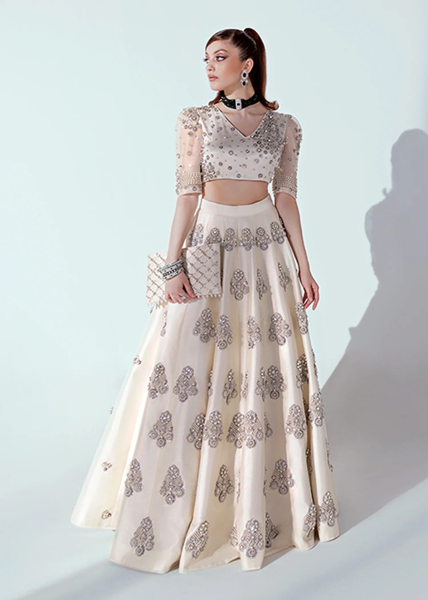 White and silver Pakistani lehenga choli with pearl, sequin, and bead embellishments, v-neck puffed sleeve choli, and an organza dupatta – ideal for weddings and formal events.