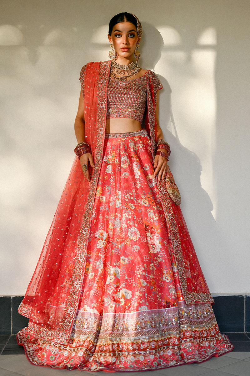 Vibrant watermelon pink Pakistani bridal lehenga with raw silk choli and ombré net dupatta featuring Swarovski accents – ideal for modern brides.