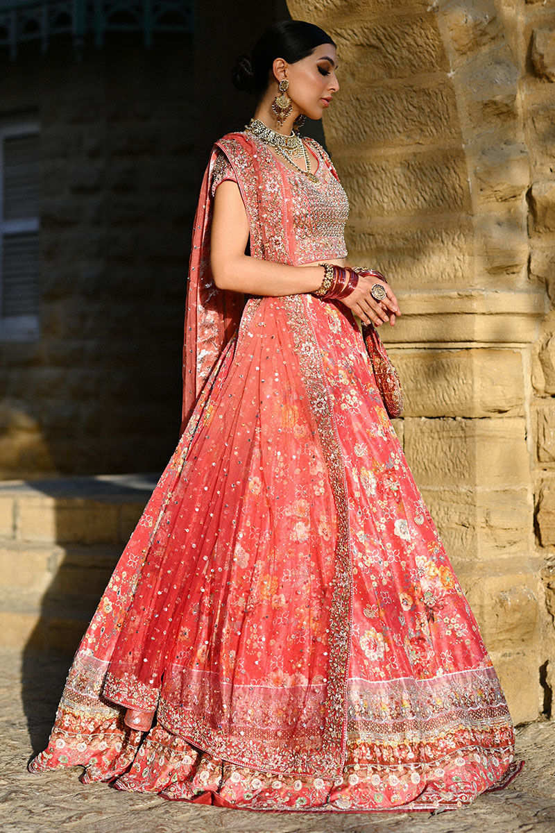 Vibrant watermelon pink Pakistani bridal lehenga with raw silk choli and ombré net dupatta featuring Swarovski accents – ideal for modern brides.