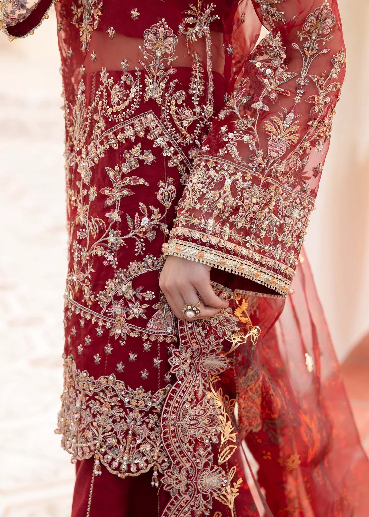 Red Pakistani flared pant suit with embroidered shirt, crystal embellishments, and printed foil dupatta – ideal for weddings and Eid events abroad.