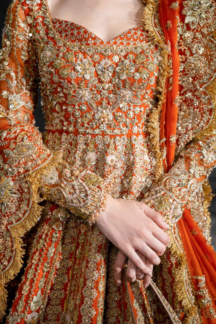 Orange bridal lehenga with gold embroidery, full sleeves, and scalloped dupatta – perfect for South Asian weddings abroad.